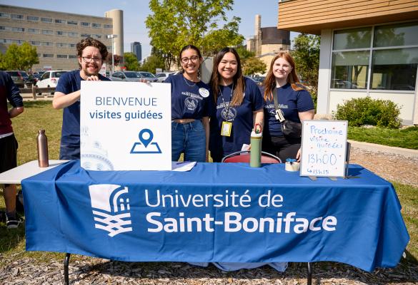 Groupe d’étudiants accueillants lors de la rentrée, avec une pancarte lisant« Bienvenue visites guidées » visible au premier plan.