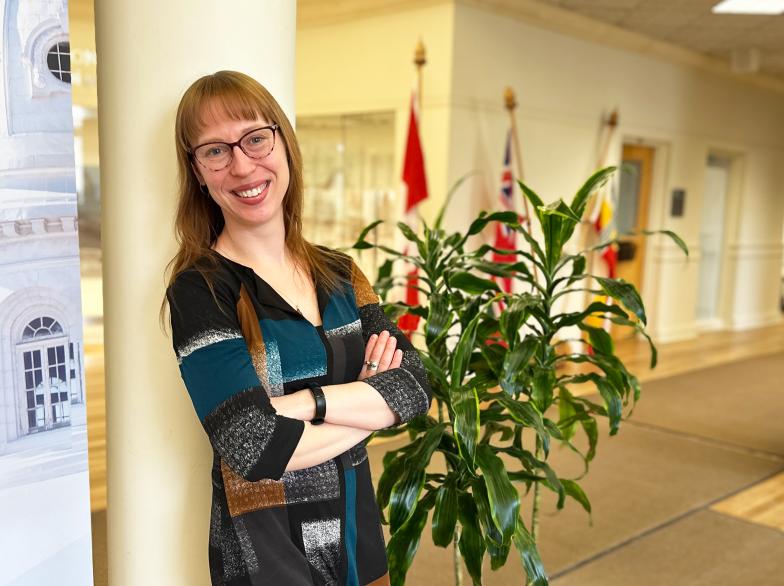Toute souriante, Amber Wojtowicz s'accote sur un poteau au hall Provencher de l'USB, les bras croisés..