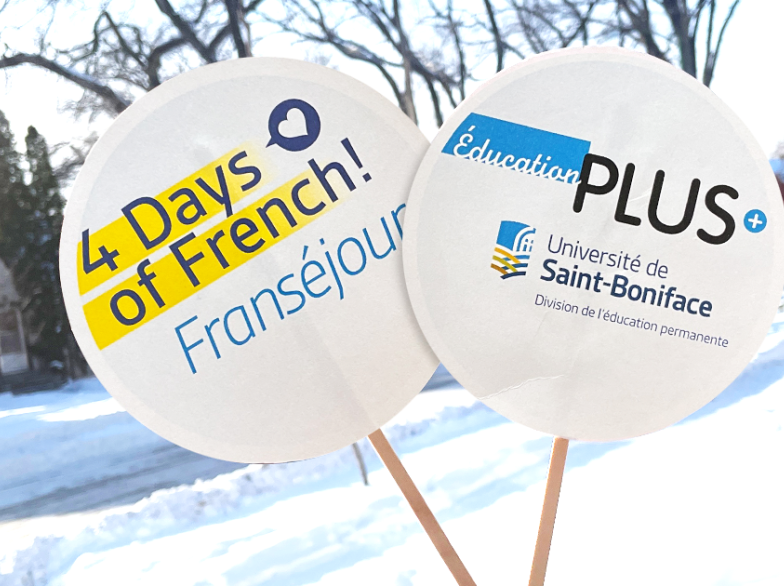 Deux pancartes rondes en papier sur fond hivernal. L'une affiche « 4 Days of French! Franséjour » et l'autre « Éducation PLUS – Université de Saint-Boniface, Division de l’éducation permanente ».