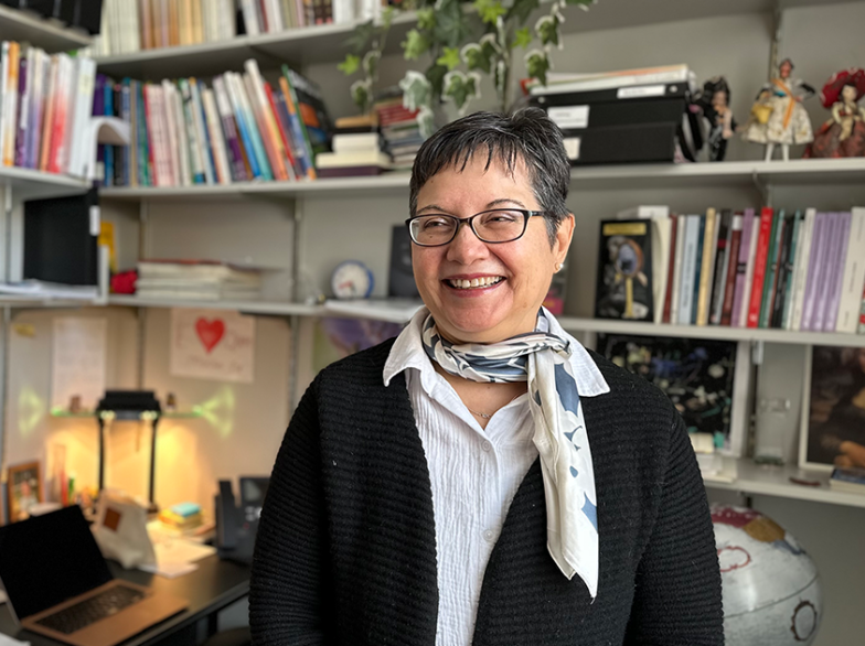 Maria Fernanda Arentsen sourit dans son bureau rempli de livres, symbolisant son engagement pour l’enseignement des langues à l’USB.