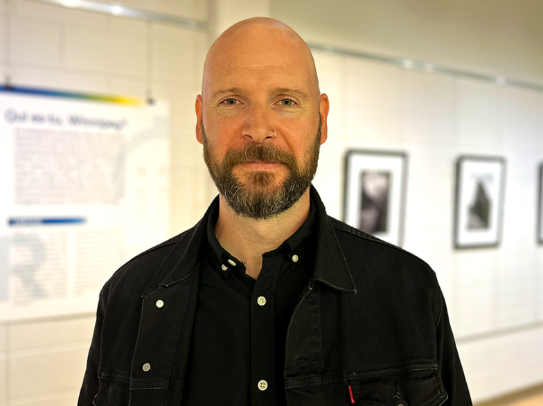 Robert Nicolas pose devant sa série de photos exposée à la Galerie de l’USB, explorant Winnipeg sous un angle artistique et géométrique.