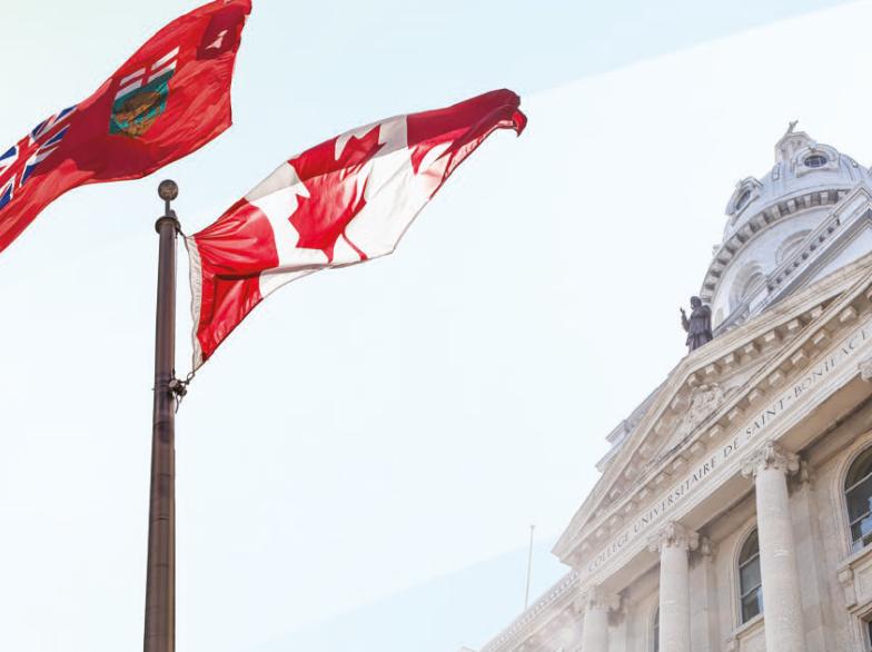 Drapeaux du Canada et du Manitoba flottant devant la façade historique de l’Université de Saint-Boniface.