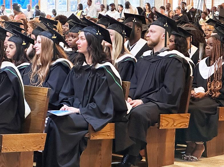 Les finissantes et finissants écoutent attentivement aux discours, assis en rangée dans les bancs de la cathédrale, lors de la collation des grades.
