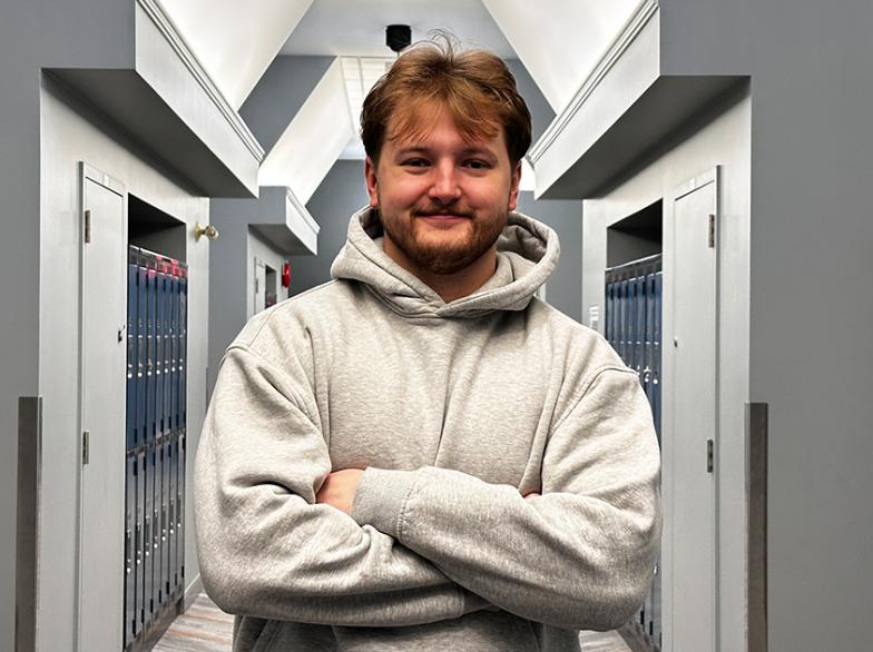 Sam Haworth, étudiant en psychologie, debout dans un corridor.