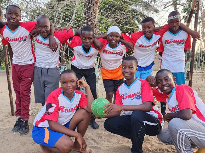 Une équipe de jeunes athlètes en Tanzanie portant fièrement le gilet des Rouges.