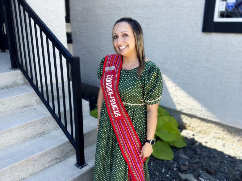 Sylvie Saltel Lawrie, diplômée de l'USB, vêtue d'un habit traditionnel et d'une écharpe sur laquelle est écrit « canadien-français ».