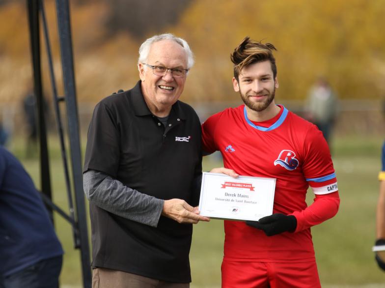 Derek Mains accepte un certificat du Meilleur joueur de la MCAC.