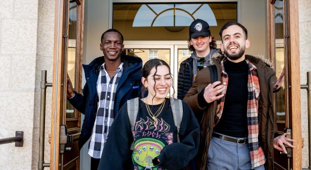 Quatre jeunes étudiants souriants de l'USB sortant du campus.