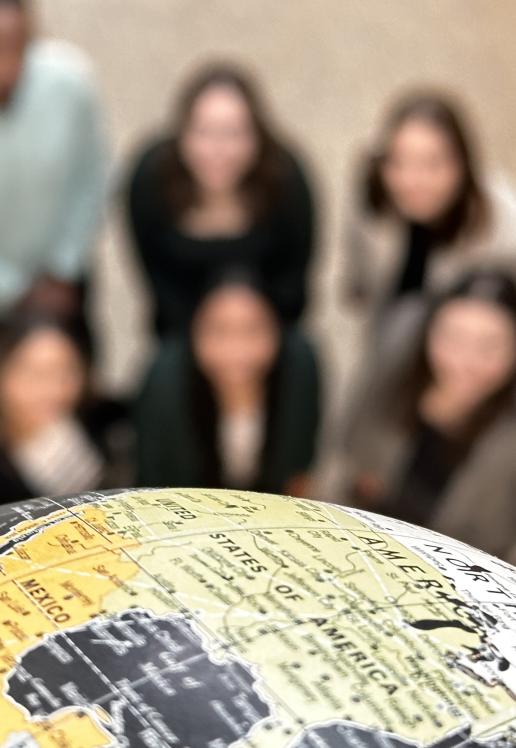Un globe mis en évidence, des silhouettes floutées de personnes sont vues de haut.