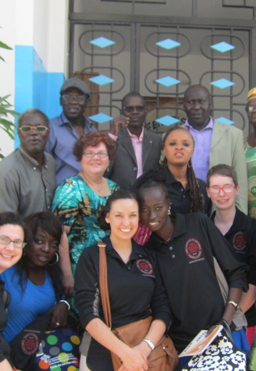 Un groupe étudiant réuni devant un bâtiment bleu et blanc dans un pays tropical.