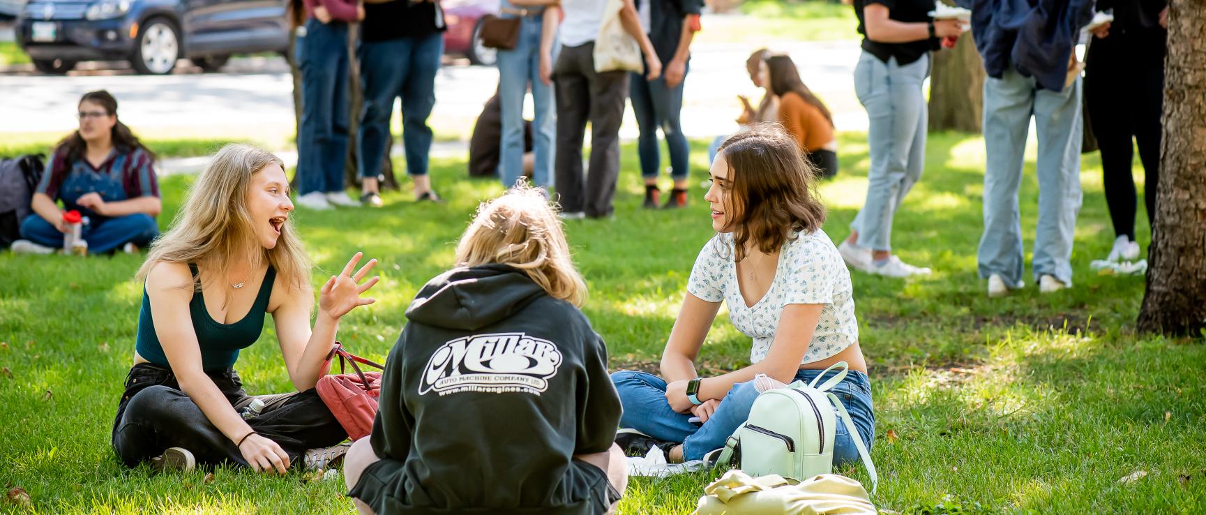 Étudiantes et étudiants échangeant en petits groupes sur le campus de l'USB