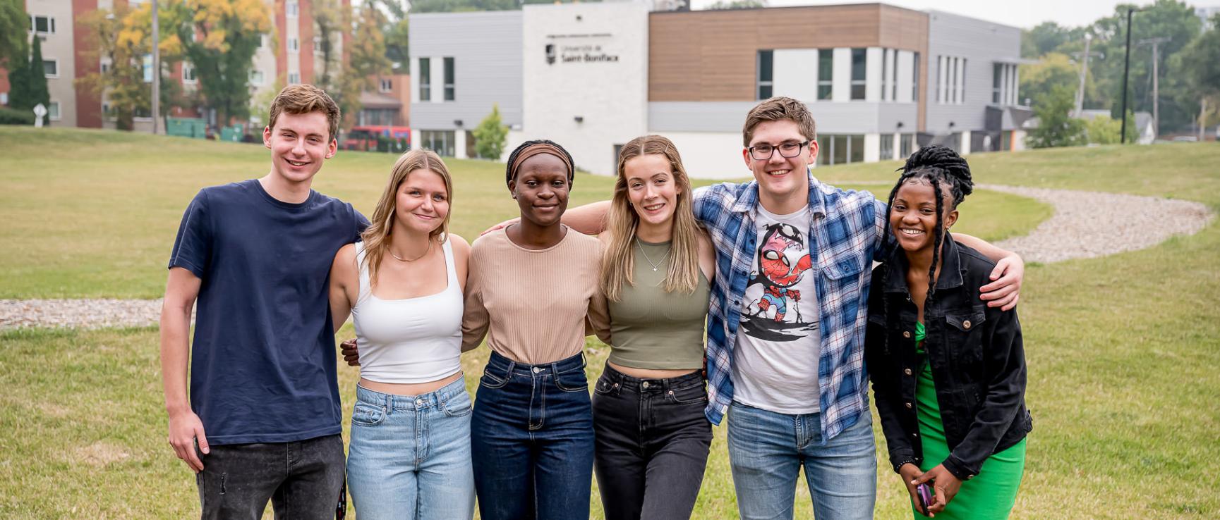 Un groupe d'étudiants réunis dehors dans un espace vert sur le campus de l'université.
