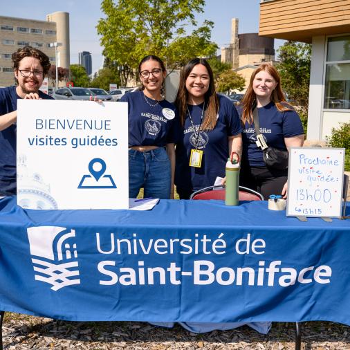 Groupe d’étudiants accueillants lors de la rentrée, avec une pancarte lisant« Bienvenue visites guidées » visible au premier plan.
