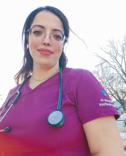 Une jeune femme avec des lunettes en tenue d'infirmière.